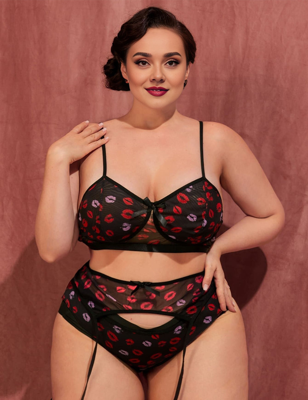 Women wearing a black lingerie set with red and pink floral pattern against a pink background