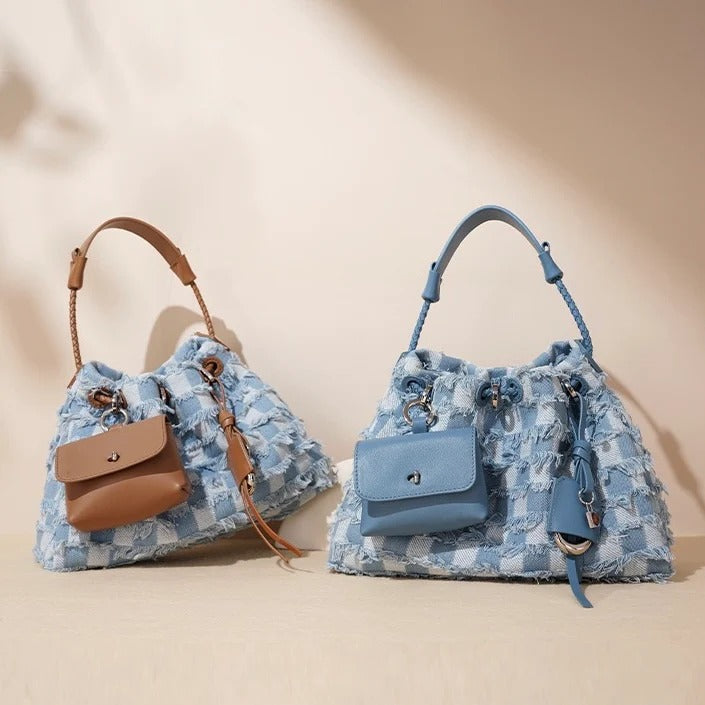Two blue floral-patterned handbags with brown accents