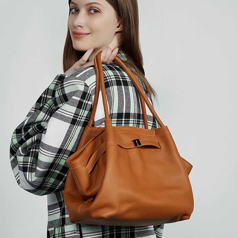 Woman holding a brown leather handbag