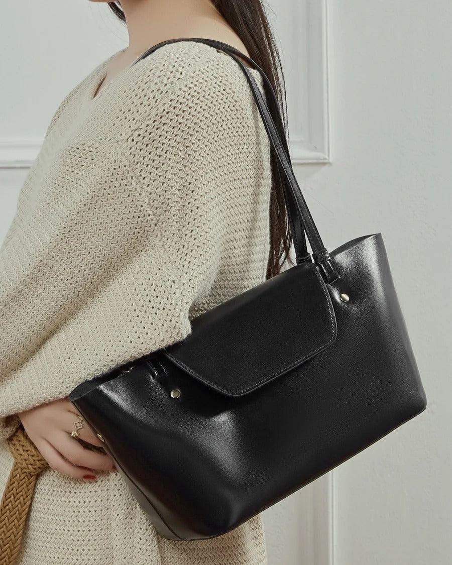 Person holding a black Leather handbag
