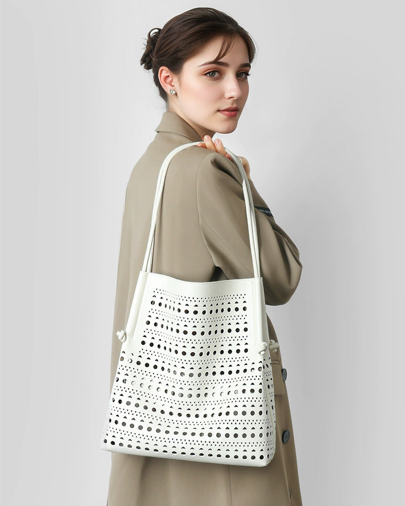 Woman wearing a creamy white Perforated tote bag