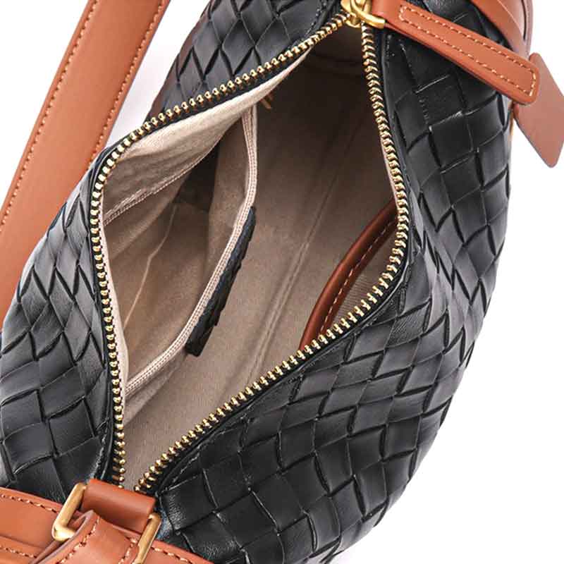 Black woven handbag with brown accents and gold zipper, open to show interior.