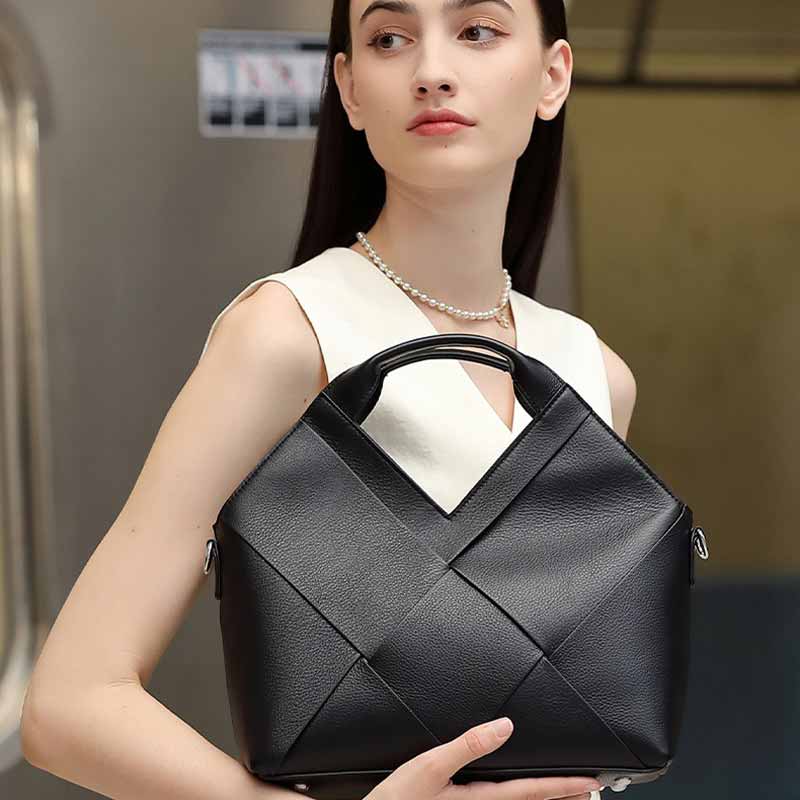 Woman holding a black Leather woven handbag