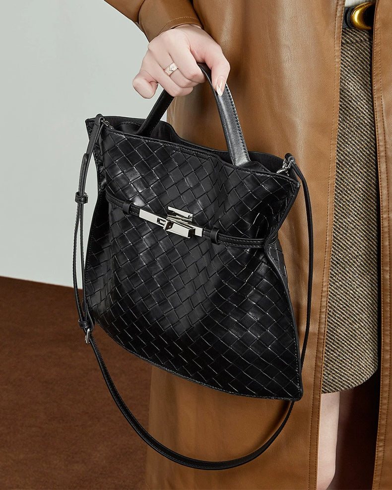 Person holding a black woven handbag