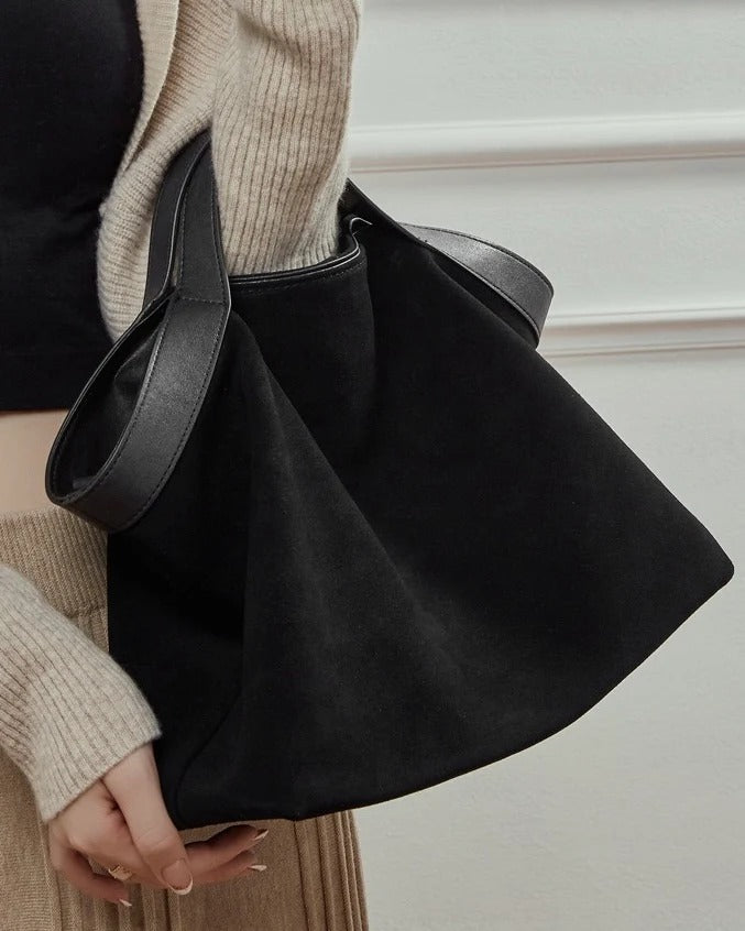 Person holding a black handbag