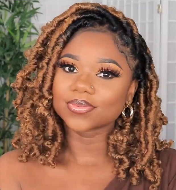 A women wearing a hand braided wig with ombre box braids, featuring a mix of dark and light brown colors.