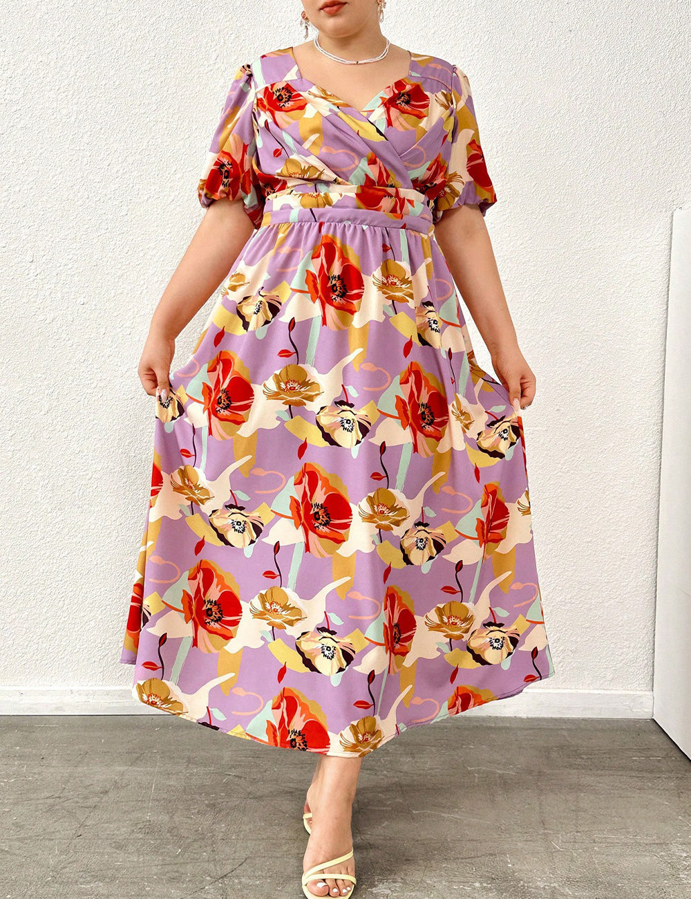 Woman wearing a colorful floral dress against a white background