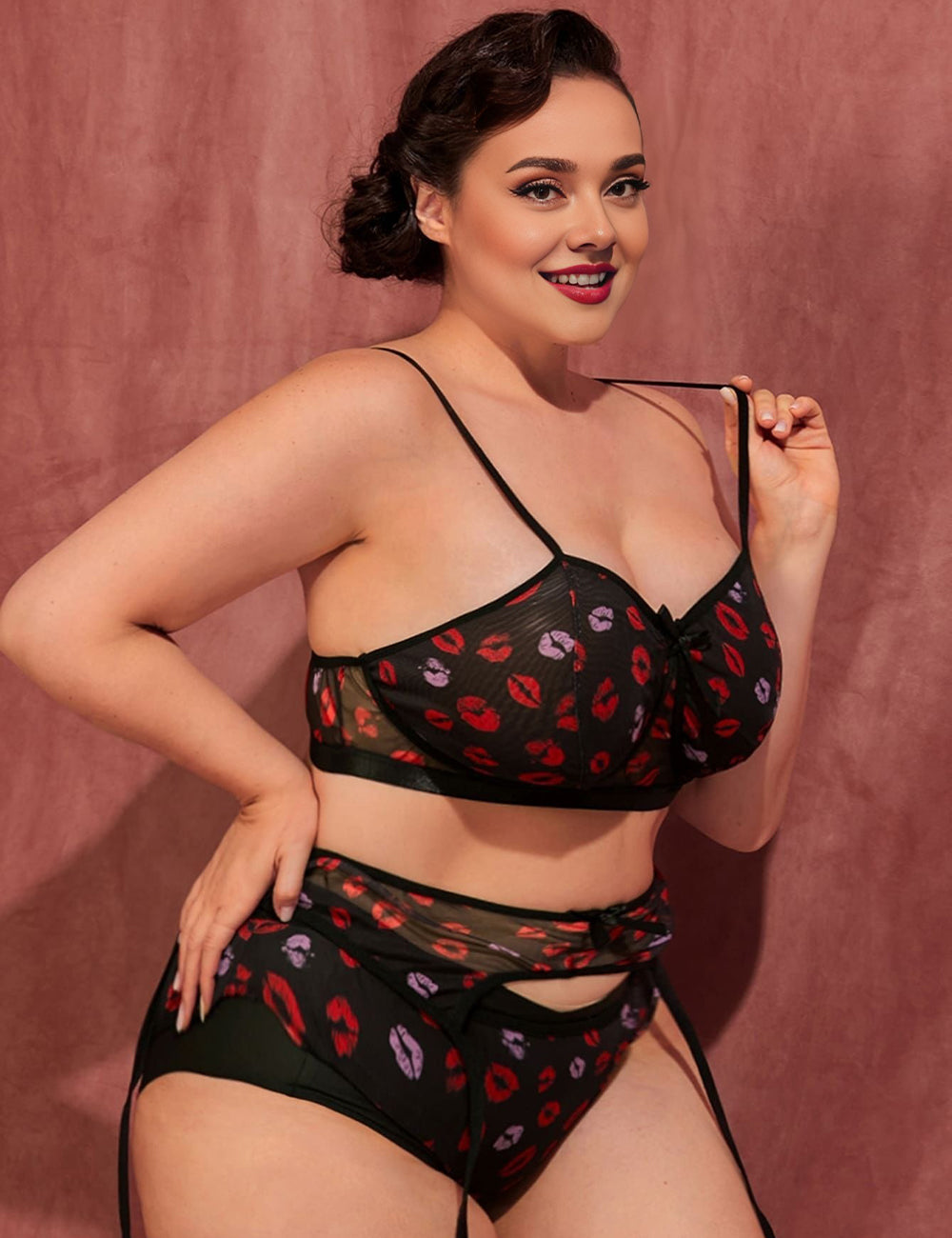 Women wearing a black lingerie set with red and pink floral pattern against a pink background