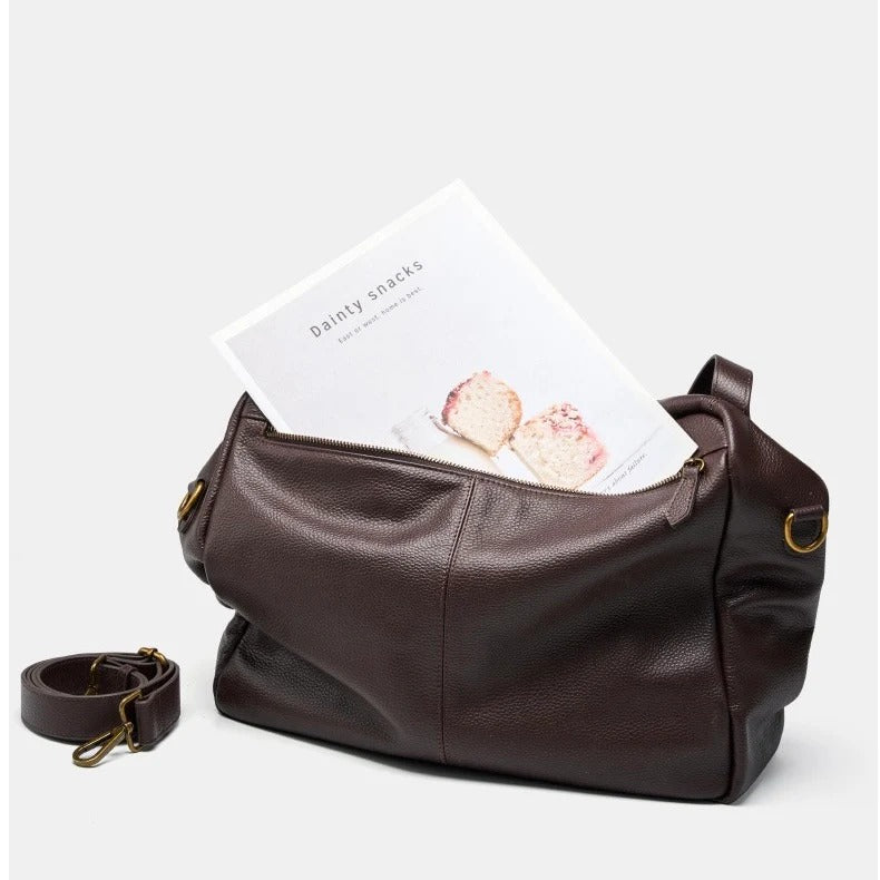 Coffee leather bag with a white card inside on a light gray background