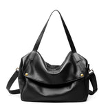Black leather handbag with gold hardware on a white background