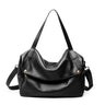 Black leather handbag with gold hardware on a white background