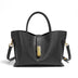 Black handbag with gold hardware on a white background