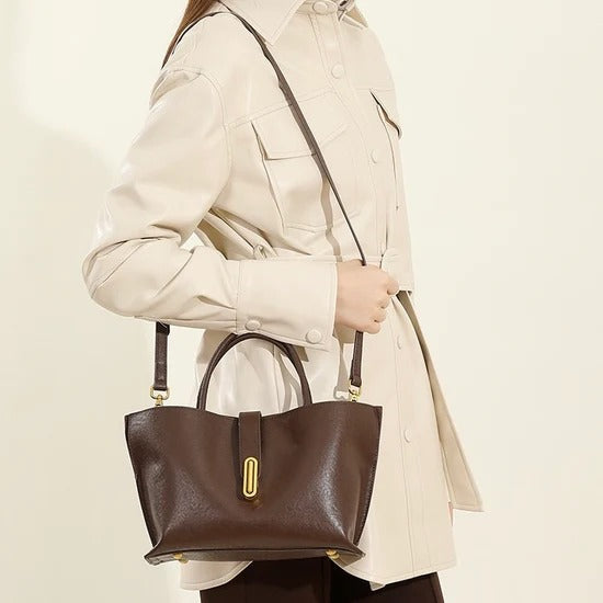 Person holding a Coffee handbag with a beige background
