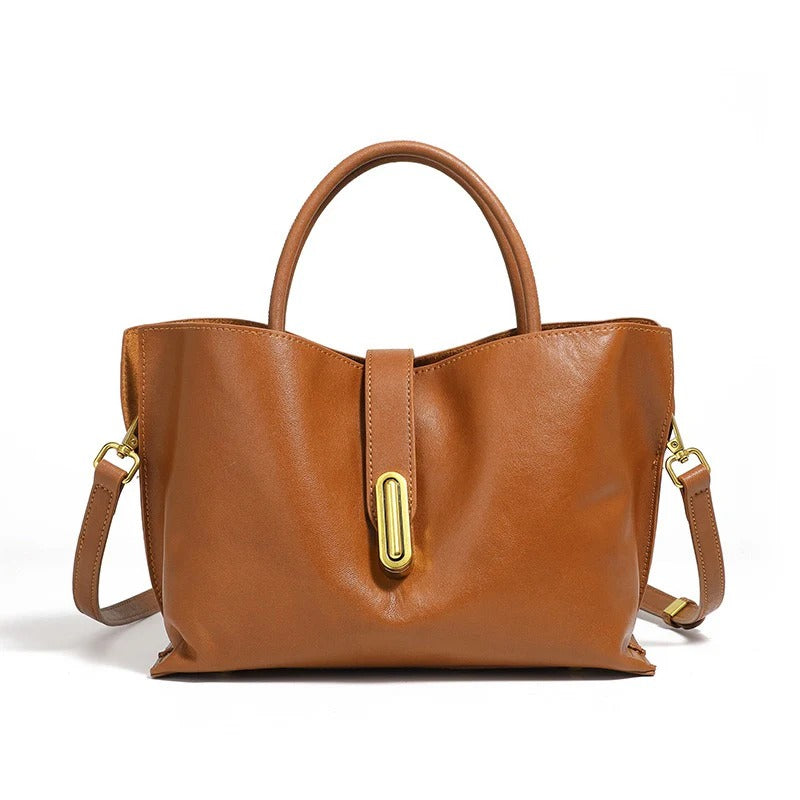 Brown leather handbag with gold accents on a white background