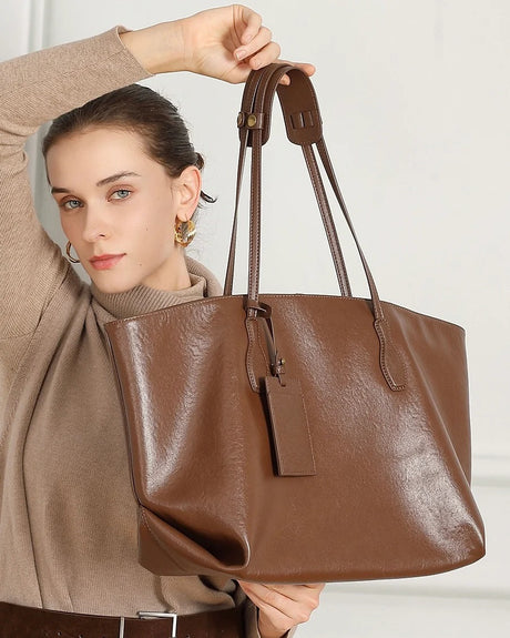 Woman holding a brown leather tote bag 