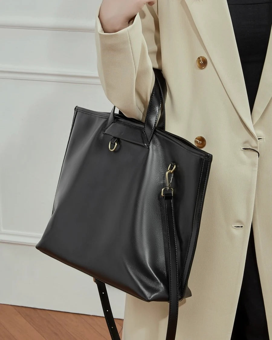 Person holding a black Full-Grain Commuter handbag 