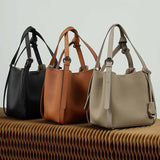 Three leather handbags in black, brown, and gray