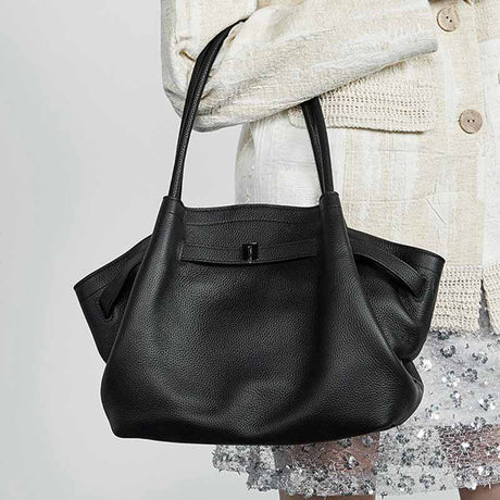 Black Genuine Leather handbag held by a person 