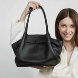 Woman holding a black leather handbag 
