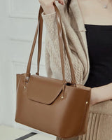 Brown handbag held by a person 
