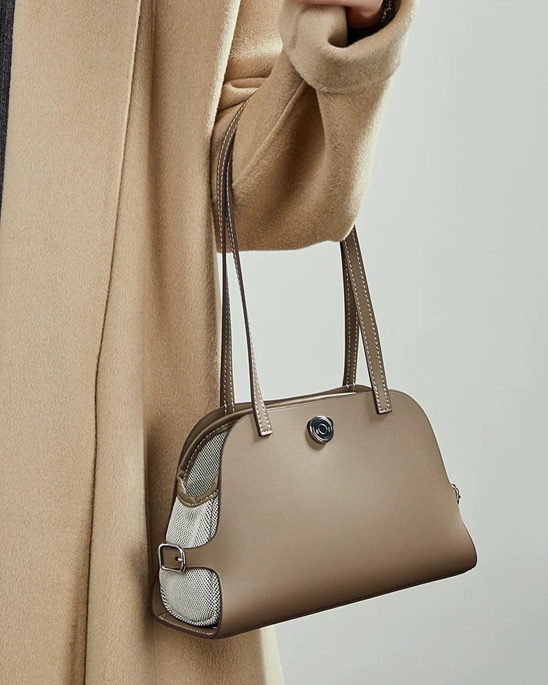 Gray handbag held by a person 