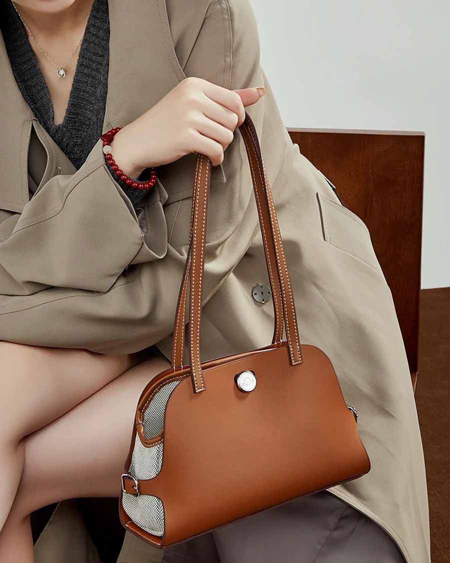 Person holding a leather  brown Saddle bag 