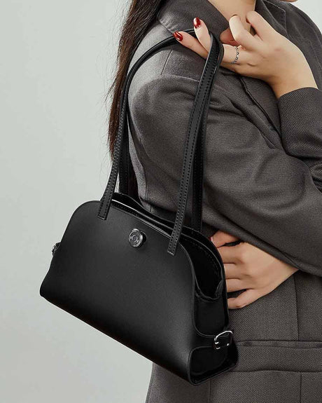 Person holding a black Genuine Leather handbag 