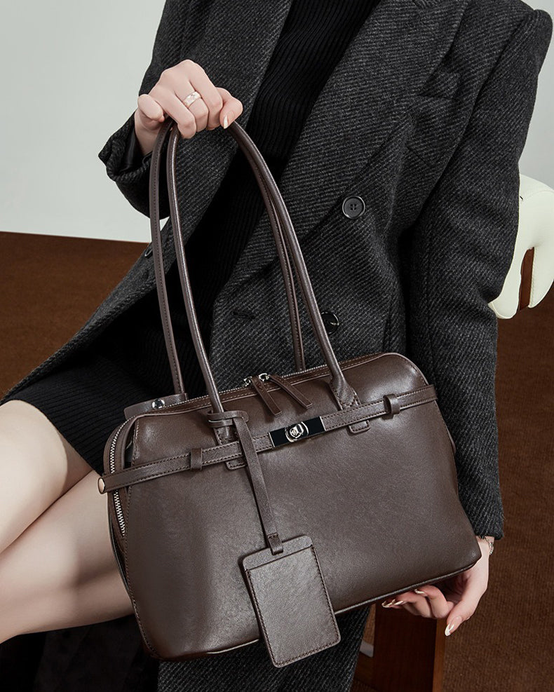 Person holding a chocolate leather handbag 