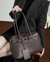 Person holding a chocolate leather handbag 