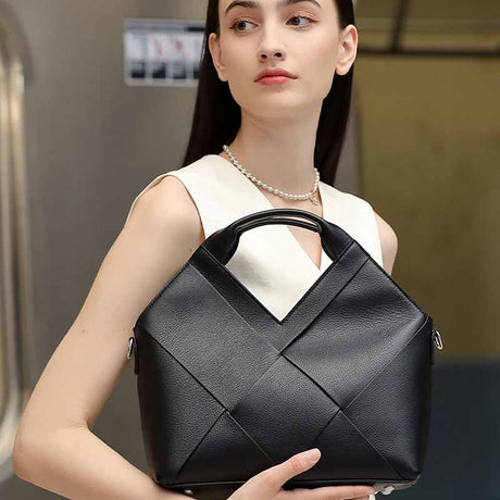 Woman holding a black Leather woven handbag 