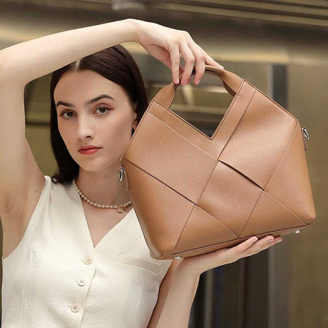 Woman holding a khaki woven handbag 