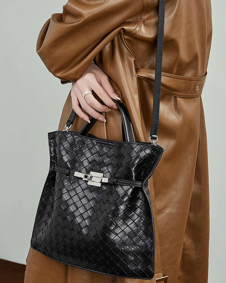 Person holding a black woven handbag 