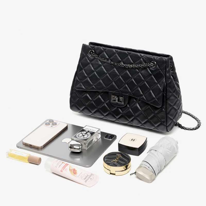 Black quilted handbag with various items 