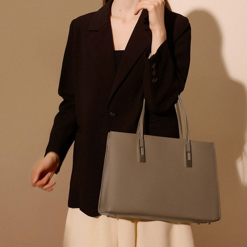 Person holding a gray Leather handbag