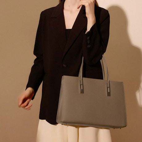 Person holding a gray Leather handbag