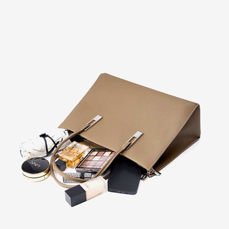 Open gray handbag with makeup items 