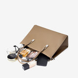 Open gray handbag with makeup items 