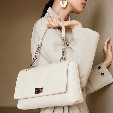 Woman holding a white quilted handbag 
