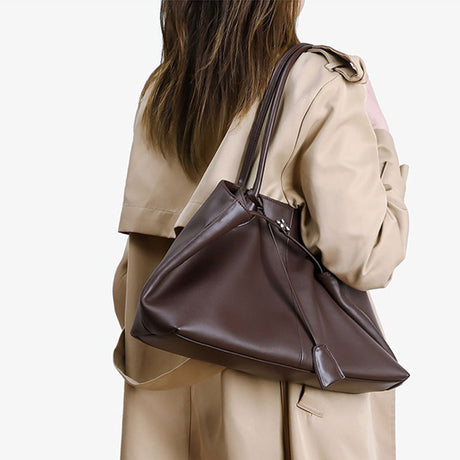 Person wearing a coffee leather handbag 