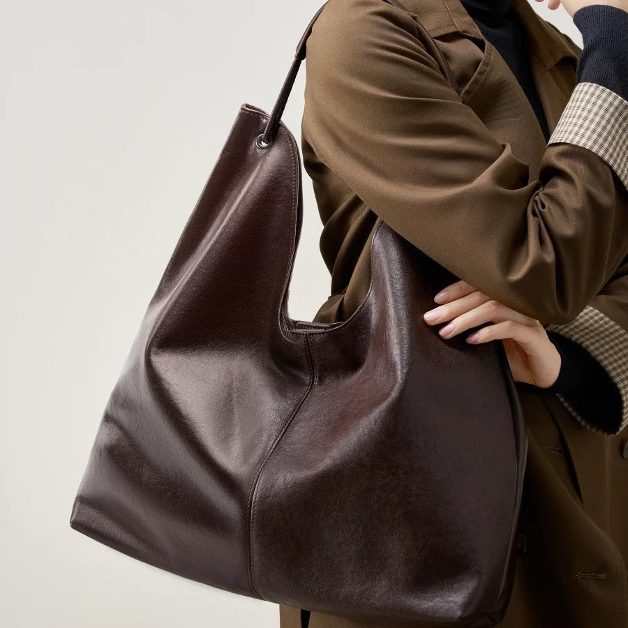 Person holding a coffee leather bag 