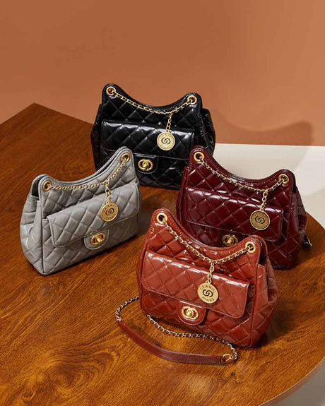 Four quilted hobo bags in gray, burdundy, caramel,and black with gold chains 