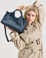 Woman holding a blue handbag 