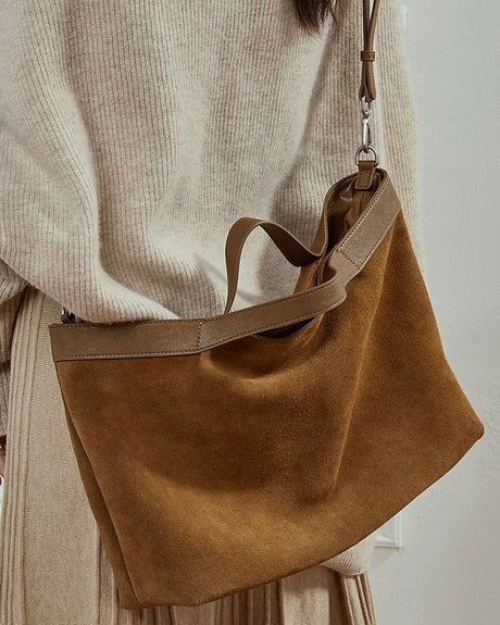 Brown suede handbag held by a person 