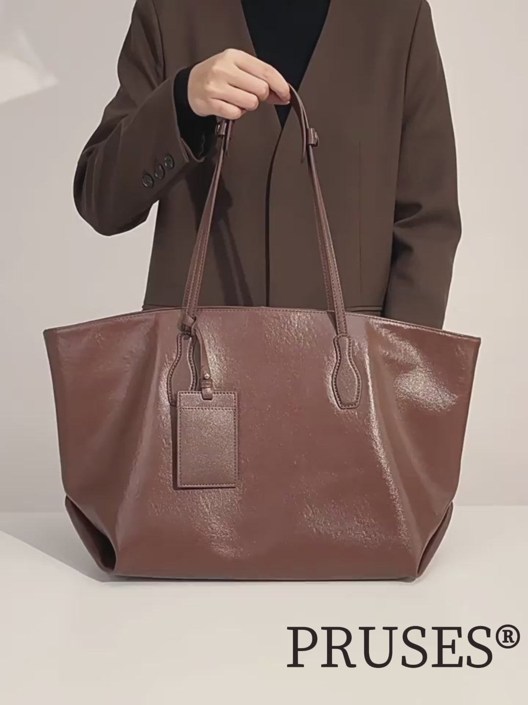 Woman presenting the brown Women’s Elegant Full-Grain Leather Everyday Tote Bag Detail PRUSES video.